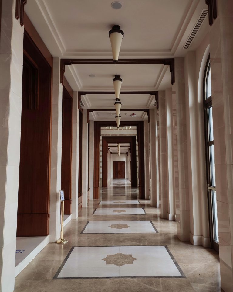 About Luxurious and elegant marble corridor with classical interior design elements in a hotel setting.